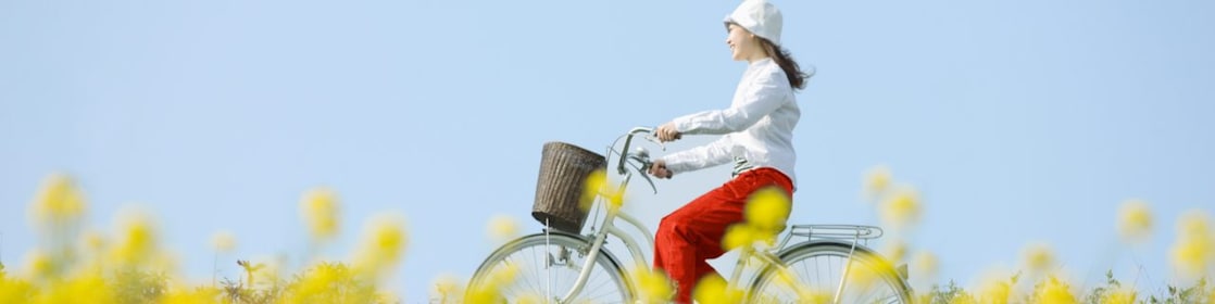 Une jeune femme fait une balade à vélo dans un champ en été