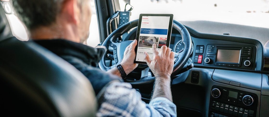 Homme au volant d’un camion, tenant une tablette