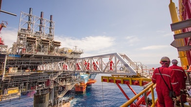 Ouvriers traversant une nouvelle plate-forme de compression sur le projet en eau profonde de Malampaya