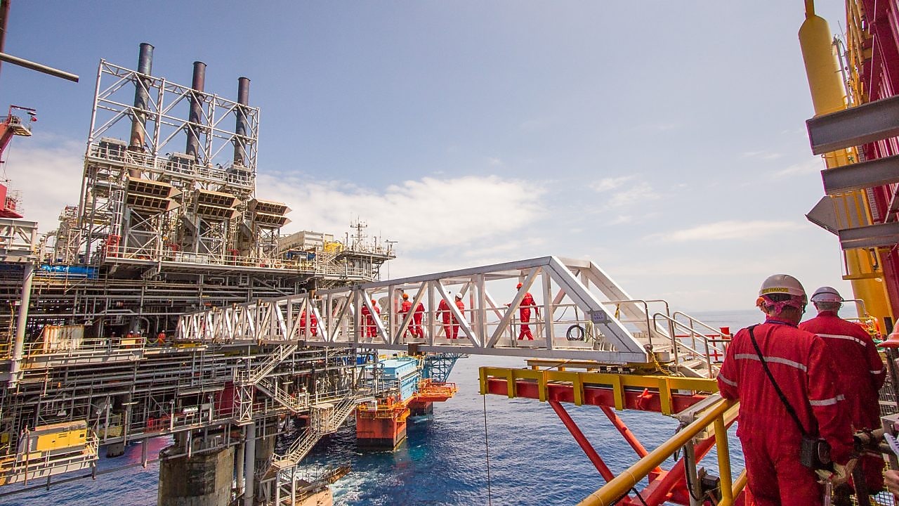 Ouvriers traversant une nouvelle plate-forme de compression sur le projet en eau profonde de Malampaya