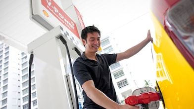 Un homme fait le plein de sa voiture