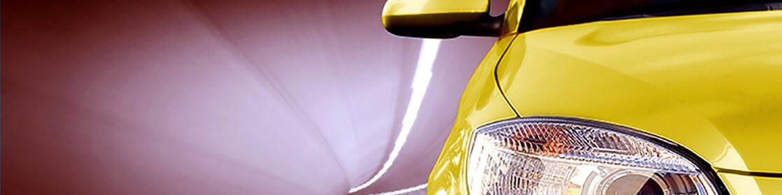L'avant d'une voiture jaune dans un tunnel, feu avant droit et rétroviseur extérieur
