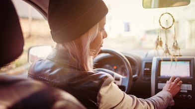 Une jeune femme consulte les instructions du GPS de sa voiture