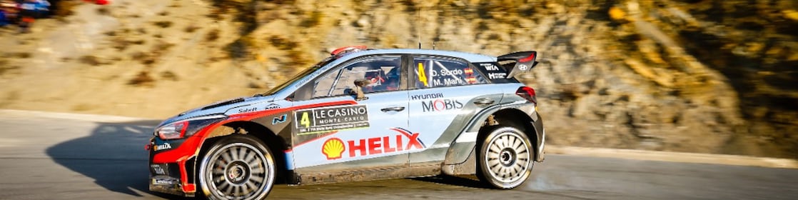Une voiture de rallye en dérapage sur une route du championnat du monde des rallyes