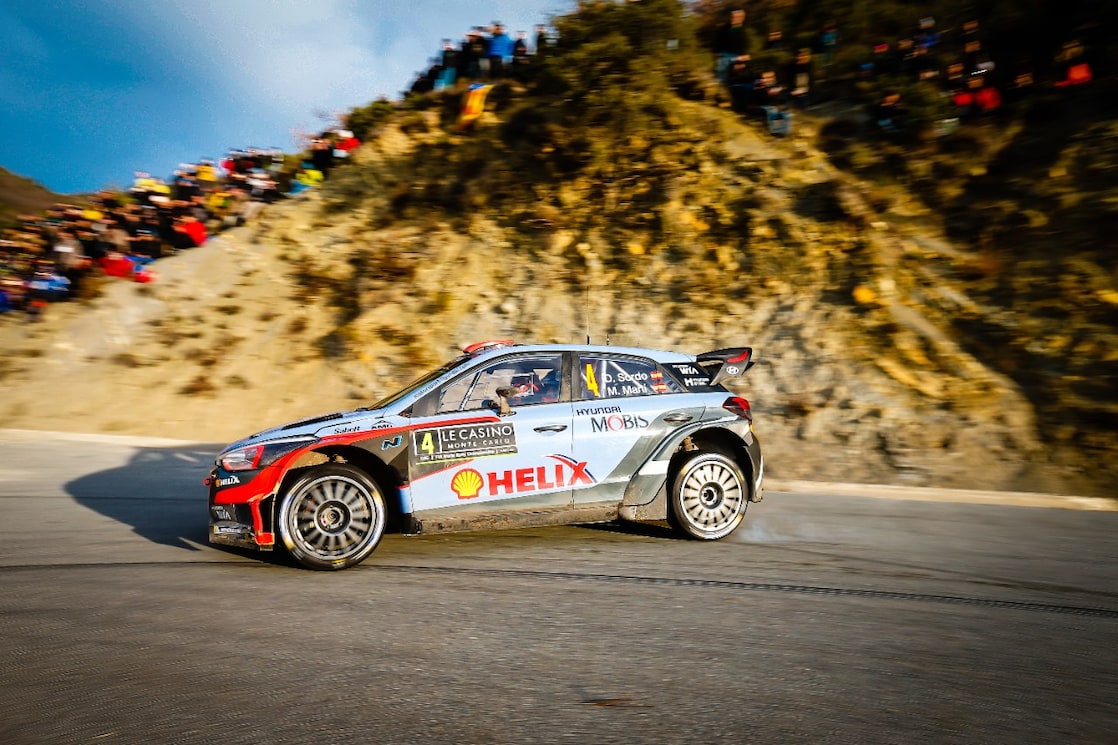 Une voiture de rallye en dérapage sur une route du championnat du monde des rallyes