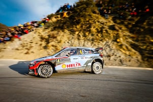 Une voiture de rallye en dérapage sur une route du championnat du monde des rallyes