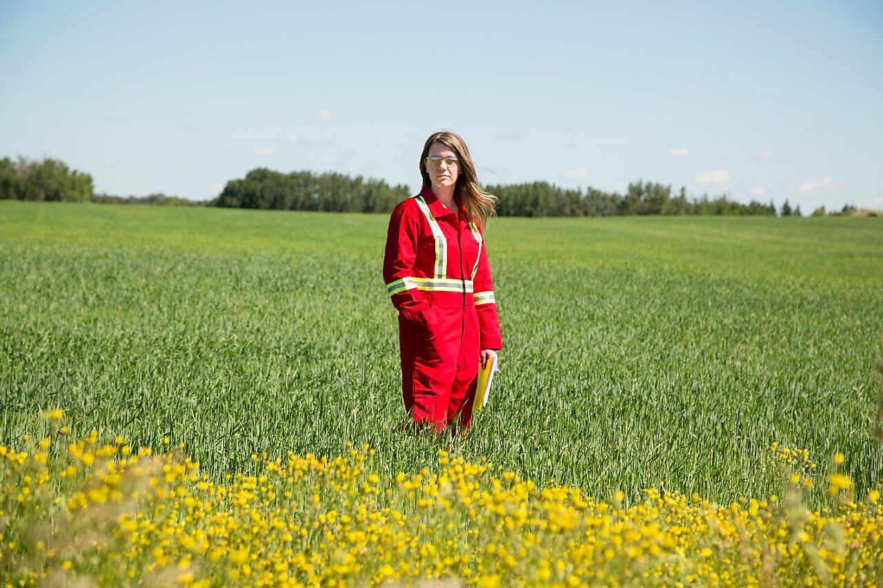 Employée se tenant dans un champ près d'un puits d'injection de CO2 dans le cadre du projet Quest, au nord-est d'Edmonton, dans la province de l'Alberta au Canada